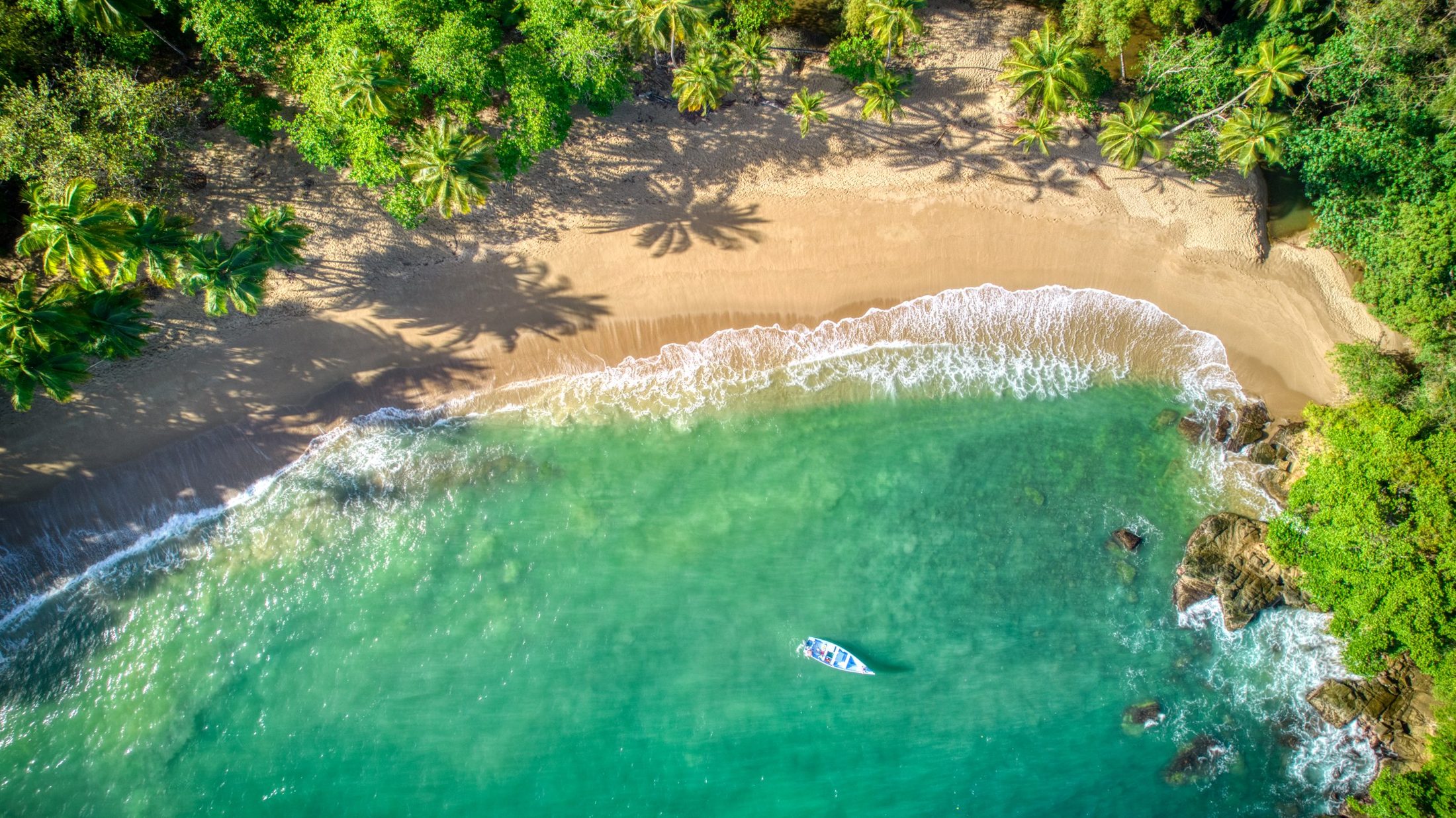 Bucht auf Tobago mit Boot im türkisfarbenen Wasser
